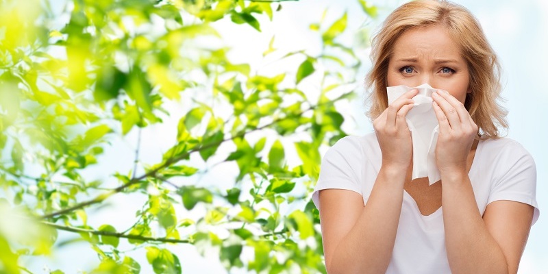 unhappy woman with paper napkin blowing nose