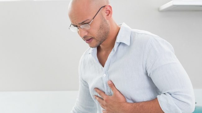 Casual man suffering from chest pain at home