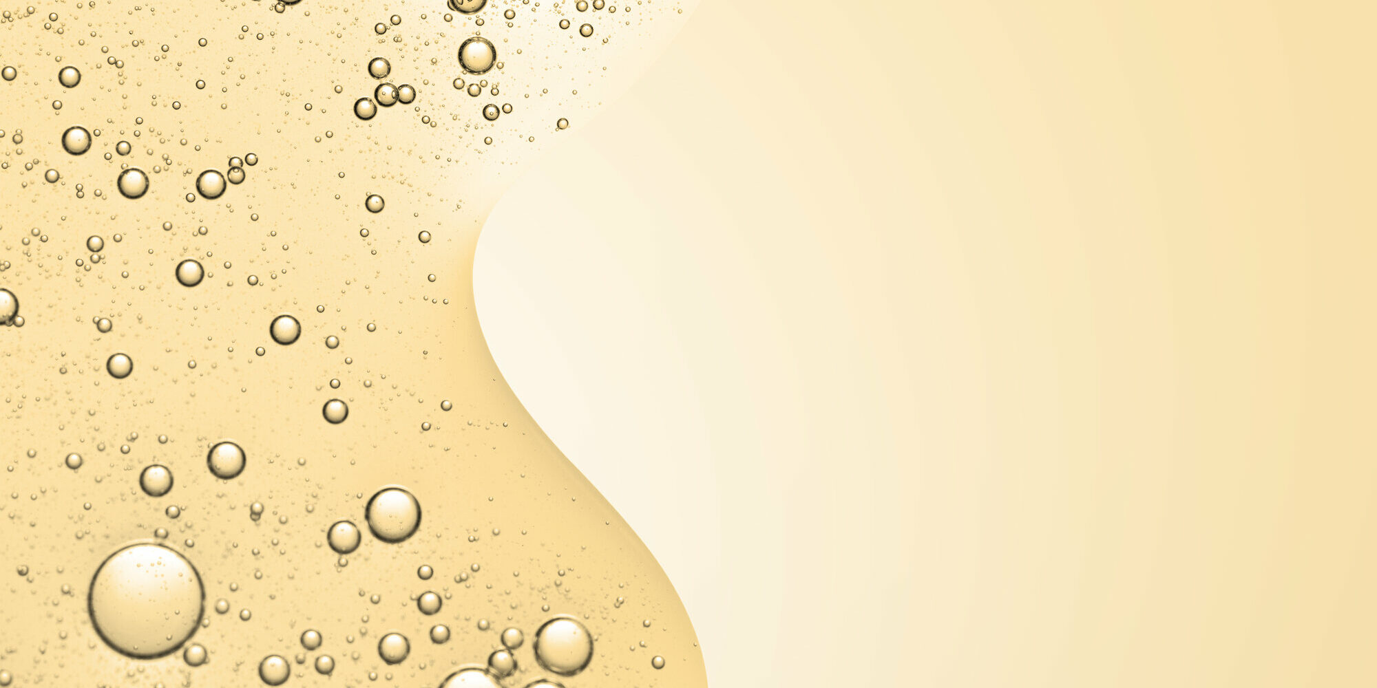 kollagen.jpg Goldfarbener Flüssigkeitshintergrund mit zahlreichen Blasen, die eine glatte, fließende Struktur bilden.